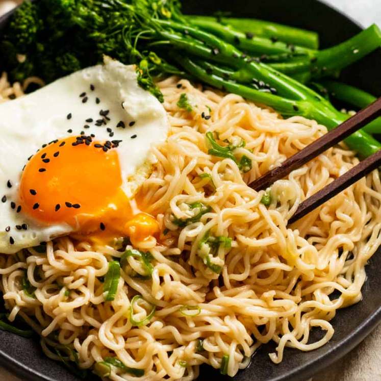 Bowl of Garlic Noodles with fried egg and broccolini