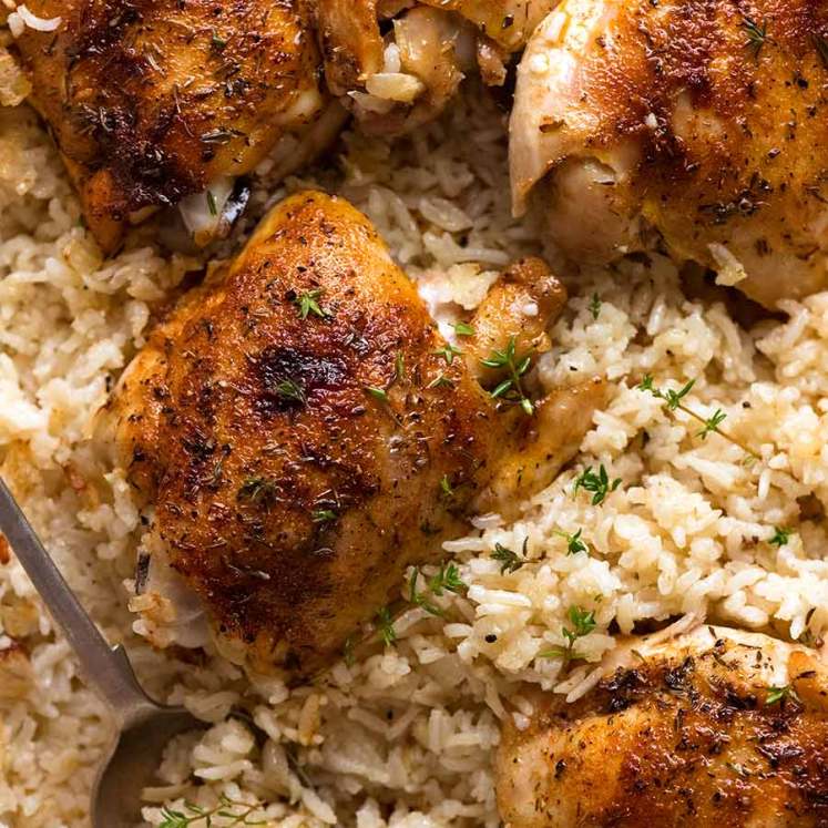 Oven Baked Chicken and Rice in a white baking pan, fresh out of the oven