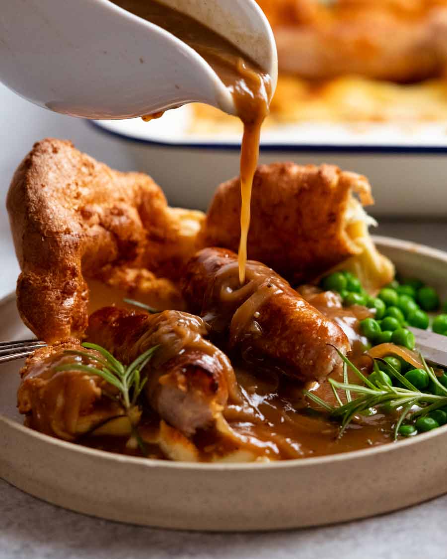 Pouring gravy over Toad in the hole